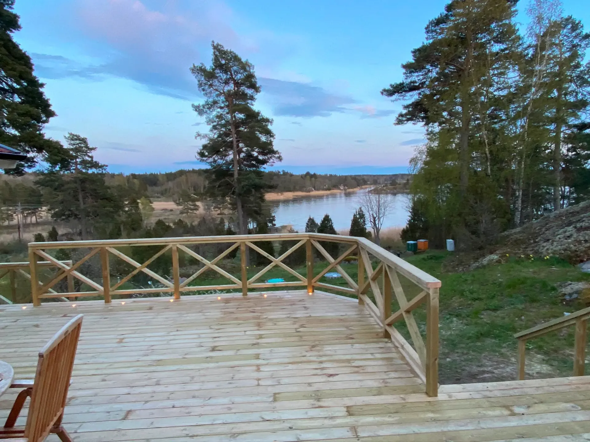 Trädäck i kvällsljus med tänd belysning