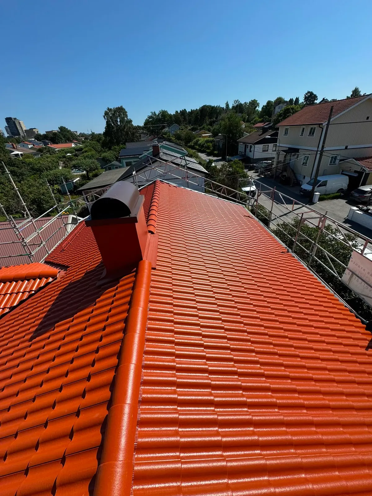 Nymålat rött tegeltak sett från nocken