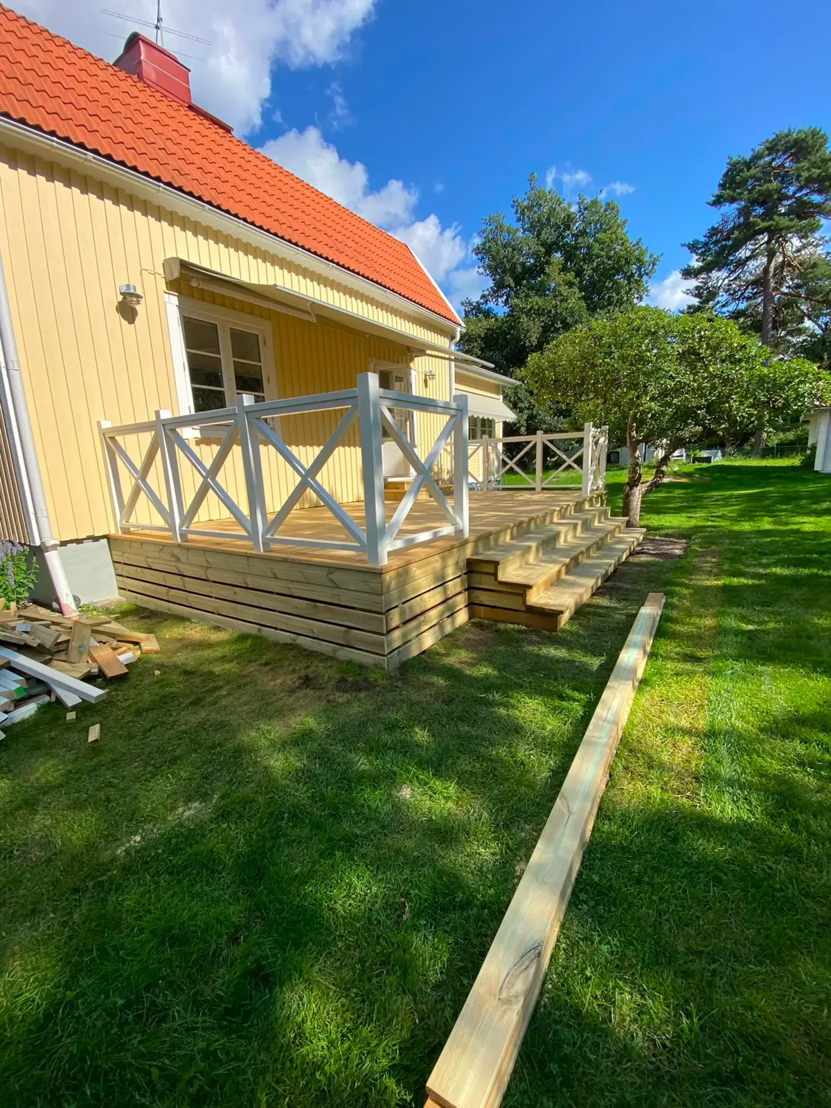 Platsbyggd altantrappa med räcke vid mörkt hus